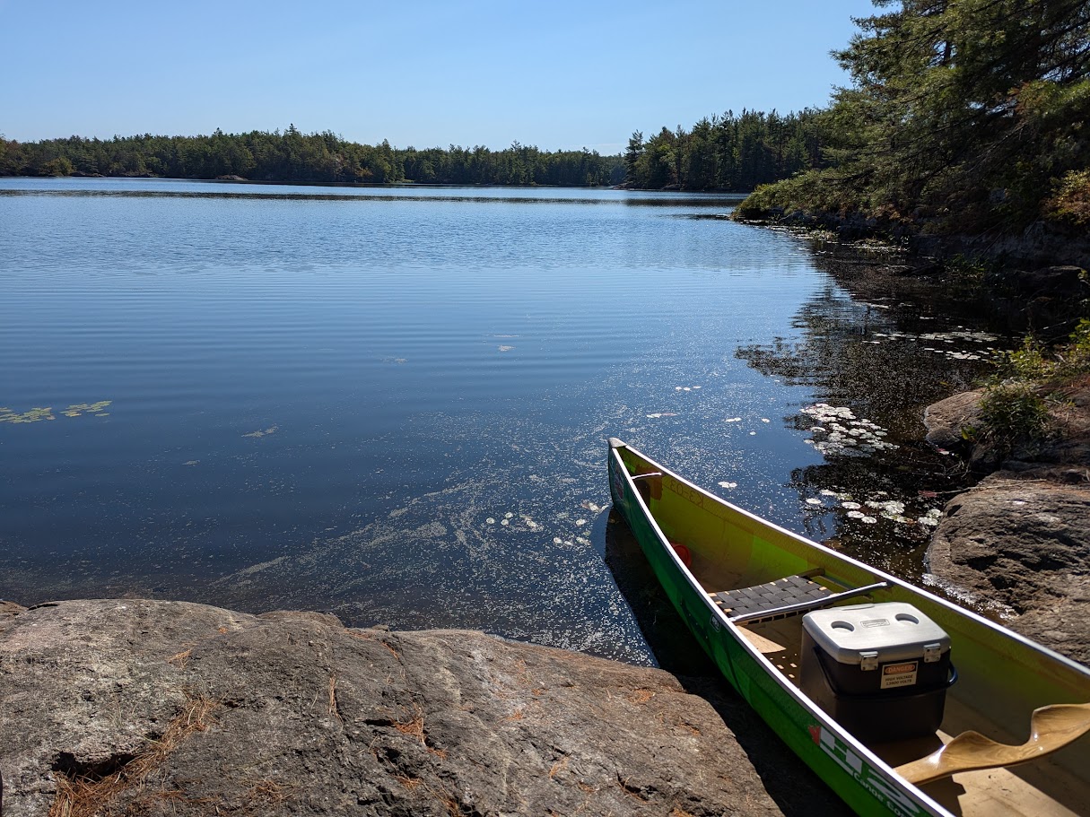 A lake with a canoe resting on shore.