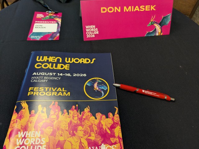 When Words Collide 2026 – A Pale Grey Retrospective A lanyard, brochure, nameplate, and pen from When Words Collide,